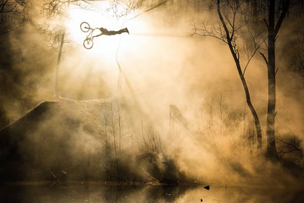Mountainbike photographer Christoph Laue had the idea of a flying Icarus. Max Mey doing a superman seatgrap on his mountainbike in fron of the sun and fog.